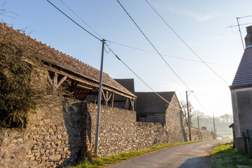 Old stone buildings in a hamlet in Creuse on a misty morning.