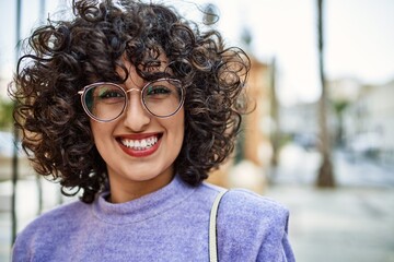 Fototapeta na wymiar Young middle east woman smiling confident wearing glasses at street
