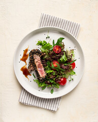 Vegetable salad, with fried tuna, in sesame seeds, healthy food, top view,