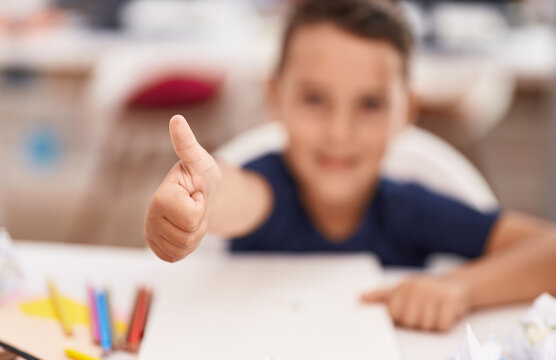 Adorable hispanic toddler student smiling confident doing ok gesture with finger at classroom