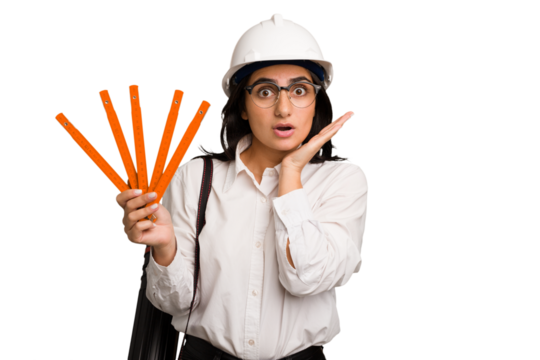 Young architect indian woman with helmet and holding a meter cut out isolated surprised and shocked.