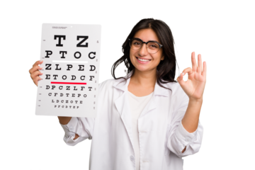 Young indian oculist woman holding an eye chart paper cut out isolated cheerful and confident showing ok gesture.