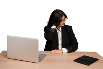 Young indian woman in a table with a laptop and tablet isolated suffering neck pain due to sedentary lifestyle.