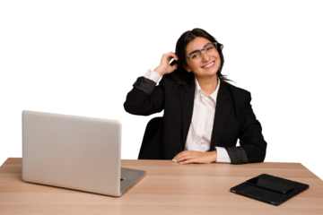 Young indian woman in a table with a laptop and tablet isolated stretching arms, relaxed position.