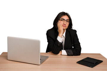 Young indian woman in a table with a laptop and tablet isolated who is bored, fatigued and need a relax day.