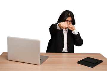 Young indian woman in a table with a laptop and tablet isolated throwing a punch, anger, fighting...