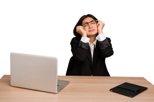 Young indian woman in a table with a laptop and tablet isolated crying, unhappy with something, agony and confusion concept.