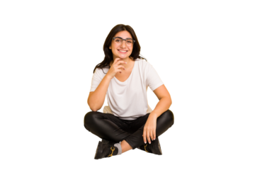 Young indian woman sitting on the floor cut out isolated smiling happy and confident, touching chin with hand.