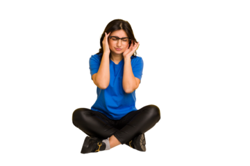 Young indian woman sitting on the floor cut out isolated touching temples and having headache.