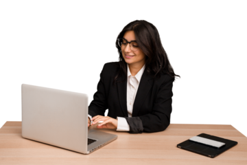 Young indian woman in a table with a laptop and tablet using a mobile phone isolated
