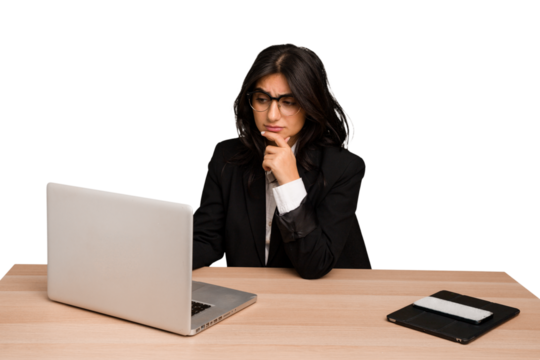 Young indian woman in a table with a laptop and tablet using a mobile phone isolated