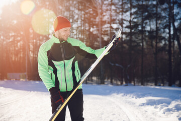 Happy man sportsman with cross country skiing background winter forest, sunny day lifestyle