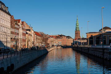 Architecture around canal in Copenhagen city centre under a bright blue sky
