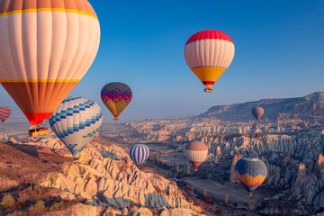 Fototapeta Amazing landscape view sunrise in Cappadocia with colorful hot air balloon deep canyons, valleys. Concept banner travel Turkey aerial top view obraz