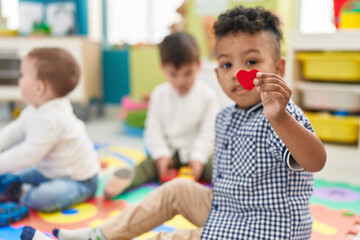 Group of kids playing with toys holding heart at kindergarten
