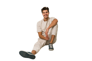 Young caucasian man sitting on the floor isolated on white background