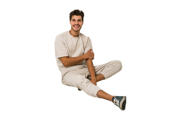 Young caucasian man sitting on the floor isolated on white background