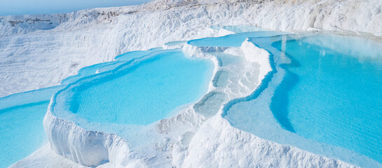 Thermal springs, natural baths Pamukkale, banner landmark of Turkey. Aerial top view blue water in...