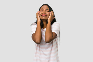 Young Indian woman cut out isolated on white background whining and crying disconsolately.