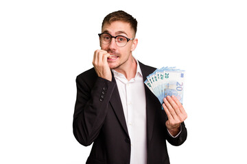 Young business caucasian man holding euro banknotes isolated cut out biting fingernails, nervous and very anxious.