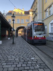 Fototapeta na wymiar Tram stop with an archway in Vienna old town and a tram pulls up