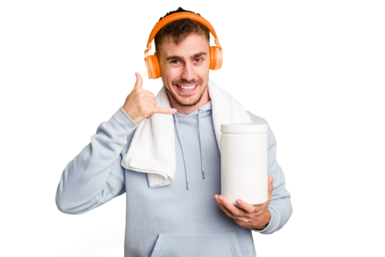 Young fitness man listening to music and holding a protein bottle isolated cut out showing a mobile phone call gesture with fingers.