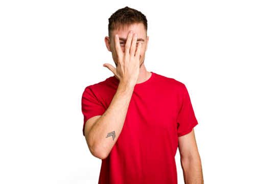 Young caucasian man cut out isolated blink at the camera through fingers, embarrassed covering face.