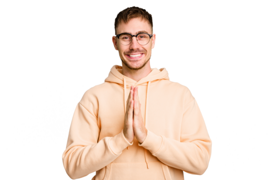 Young caucasian man cut out isolated holding hands in pray near mouth, feels confident.