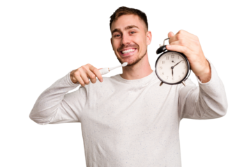 Young man holding an electric brush and an alarm clock cut out isolated