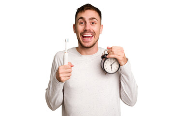 Young man holding an electric brush and an alarm clock cut out isolated