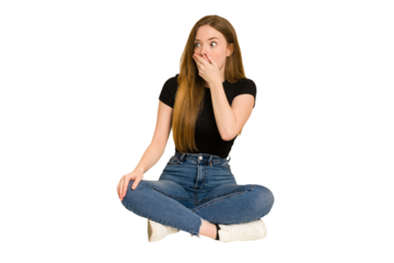Young redhead woman sitting on the floor cut out isolated thoughtful looking to a copy space covering mouth with hand.