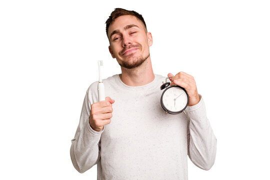 Young Man Holding An Electric Brush And An Alarm Clock Cut Out Isolated