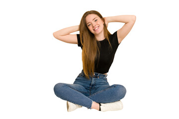 Young redhead woman sitting on the floor cut out isolated stretching arms, relaxed position.