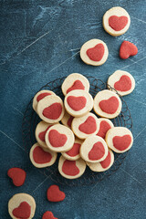 Valentines day cookies. Shortbread cookies inside a sweet red heart on parchment paper on dark blue background. Mothers day. Womans day. Sweet holidays baking. Top view.