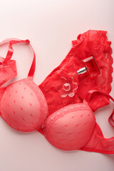 Red sexy bra and panties on pink background. Women sexy underwear set with roses and perfume. Gift...