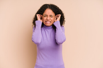 Young african american curly woman isolated covering ears with hands.