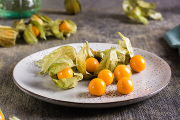 Ripe fruit physalis on a plate. Organic vegetarian food.