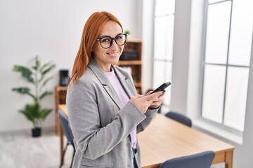 Young caucasian woman business worker smiling confident using smartphone at office