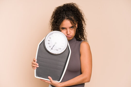 Young african american woman holding a scale isolated