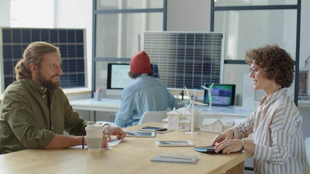 Male HR manager greeting female candidate with handshake in office and speaking with her during job interview for position of renewable energy developer