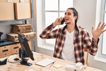 Young man ecommerce business worker talking on the smartphone at office