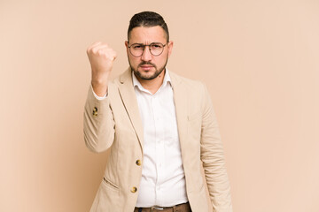 Adult latin business man cut out isolated showing fist to camera, aggressive facial expression.