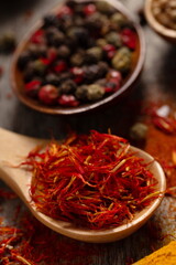 Saffron thread dried spice in spoon on table background. Herb ingredients