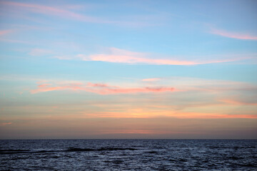 Dramatic red ocean waves at sunset with soft evening sea dark water