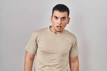 Young arab man wearing casual t shirt in shock face, looking skeptical and sarcastic, surprised with open mouth