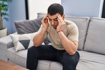 Young man stressed sitting on sofa at home