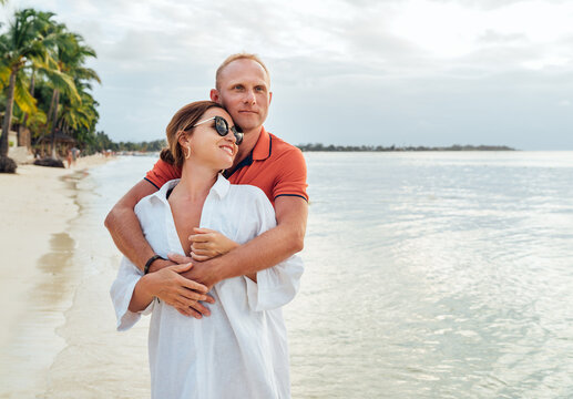 Couple in love hugging on the sandy exotic beach while they have a evening walk by the Trou-aux-Biches seashore on Mauritius island. People relationship and tropic honeymoon vacations concept image.