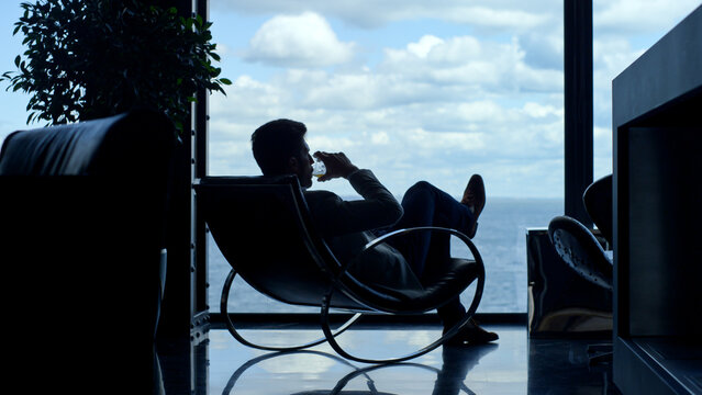 Silhouette man enjoying vacation life cognac in sea view. Businessman relaxing