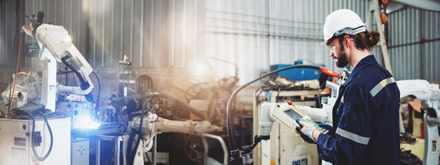 Panoramic Industrial male engineers maintenance robot arm in factory. Automation technician...