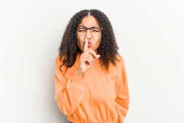 Young african american woman isolated on white background keeping a secret or asking for silence.